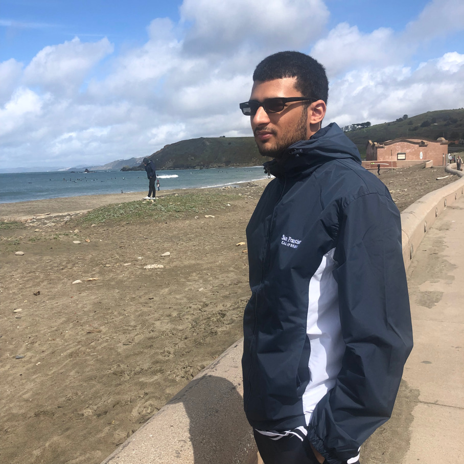 A person standing next to a body of water Description automatically generated