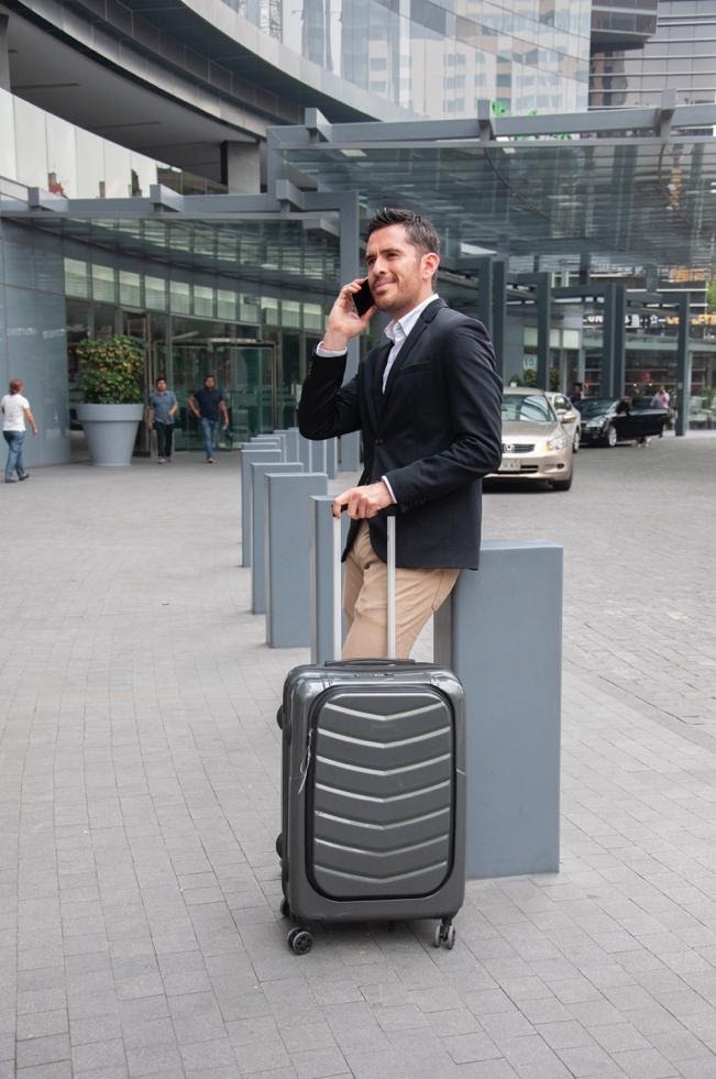A person holding a piece of luggage Description automatically generated